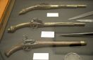 Broń, m.in. pistolet skałkowy (w środku) z XVIII wieku. Archiwum www.binzesistyl.pl